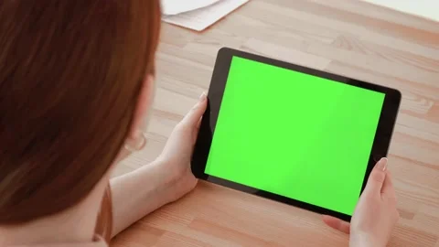 Close up shot of hands holding a tablet computer with green mock up screen. A te Stock Footage 148751471