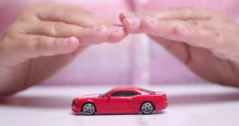 Close-up shot of hands hovering over a small toy red sportscar, Vídeo Stock 262442640