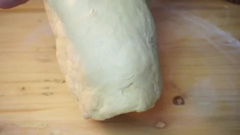 Close-up shot of hands lifting a dough on a wooden table Stock Footage 271148889