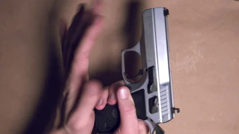 Close up shot of hands loading magazine into 9mm pistol and loading gun. Stock Footage 141004960