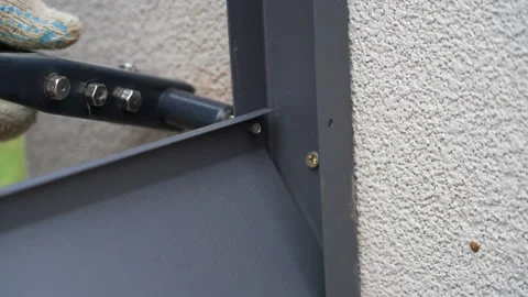 Close up shot on hands of man using rivet plier to join metal profiles to the Stock Footage 169233586