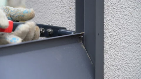Close up shot on hands of man using rivet plier to join metal profiles to the Stock Footage 169412779