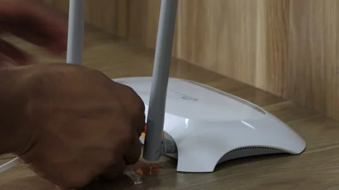 Close shot of hands plugging the ethernet cable into the wifi router Stock Footage 148757733