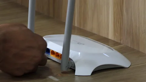 Close shot of hands plugging the ethernet cable into the wifi router Stock Footage 148757776