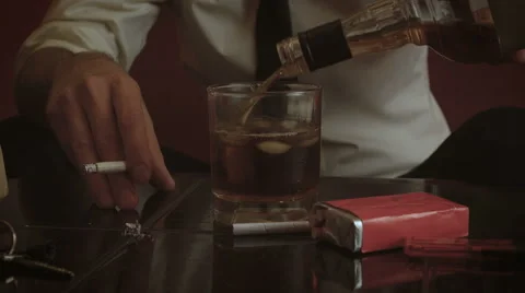 Close-up shot on hands pouring drink and holding cigarette 스톡 동영상 54756176