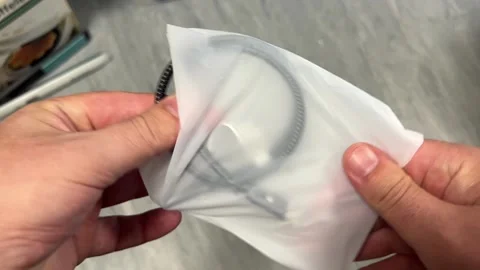 A close-up shot of hands pulling a coiled, black braided charging or data c.. Stock Footage 323139704