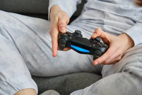 Close shot of the hands of a red-haired girl with a game console sitting on the Stock Photos
