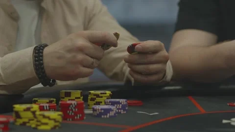 A close-up shot of hands shuffling poker chips over table Stock Footage 336240155