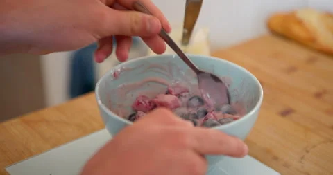 A close-up shot of hands stirring a bowl of delicious berries and yoghurt Stock Footage 336141011