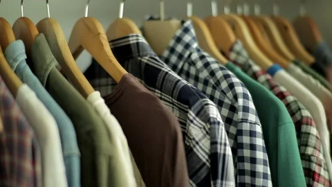 Close up shot of hands taking shirts and t shirts from coat rack Stock Footage 200194561