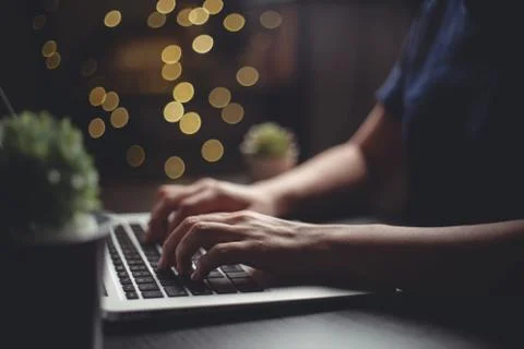 Close up shot of hands typing message for searching on laptop with glow bokeh Stock Photos