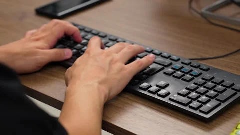 Close-up shot of hands typing quickly on a black computer keyboard Stock Footage 321284963