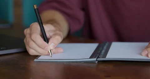 Close-up shot of hands of unrecognizable men writing down in notepad while Stock Footage 163956080