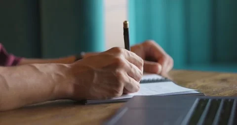 Close-up shot of hands of unrecognizable men writing down in notepad while Stock Footage 163956118