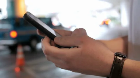 Close up shot of hands using smartphone app to call ride share car at airport Video stock 97543073