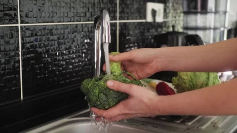 Close up shot of hands washing broccoli with running water from a faucet. Stock Footage 245350102