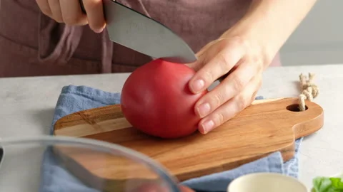 Close up shot hands of women using kitchen knife slide cut fresh tomato on Video stock 138091312
