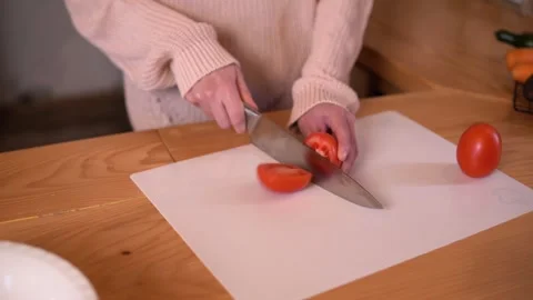 Close up shot hands of women using kitchen knife slide cut fresh tomato Video stock 308776862