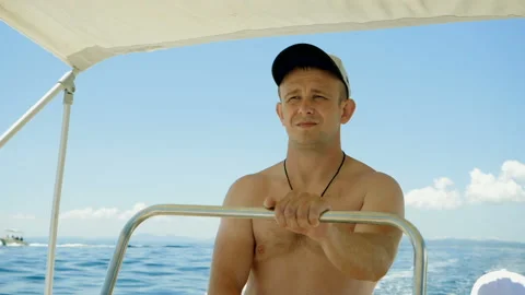 Close-up shot of handsome man at the helm of boat. Slow motion. HD Stock Footage 112599706