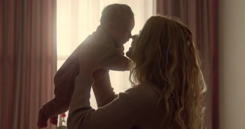 Close-up shot of happy smiling young mum holding her newborn baby boy high in 스톡 동영상 147941789