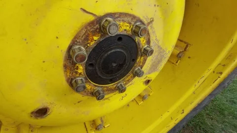 Close up shot of heavy duty tractor yellow wheel rim and rusty lug nuts Stock-Footage 346245736