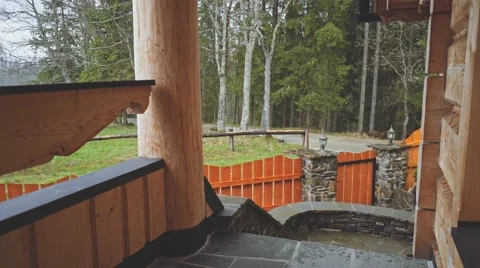 Close Up shot of heavy Rain Falling on the porch of Forest Cabin. 4K. Видео 66755590