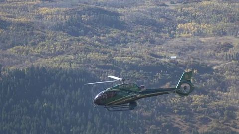 Close shot of Helicopter against fall folliage Stock Footage