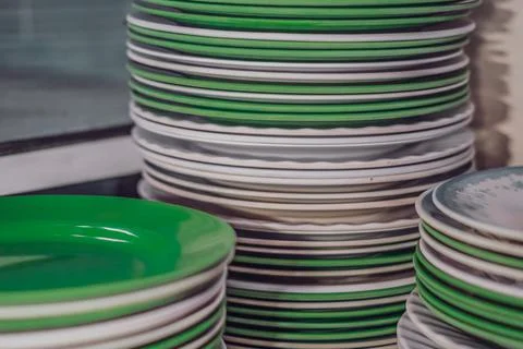 Close-up shot high stack storage of melamine plastic round white green clean Stock Photos