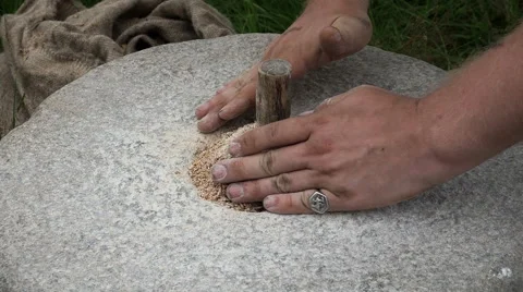 Close-up shot of historic hand-driven millstone grinding wheat Stock Footage 64653233