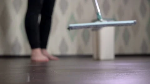 Close-up shot, hostess takes a mop for and wipes the floor Stock-Footage 153905372