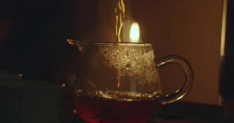 Close-up shot of hot tea pouring into glass jar slow motion. Faceless person Stock Footage 185871159