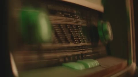 Close up shot of human hand turning tuning knob on vintage radio receiver. Stockbeeldmateriaal 337524689