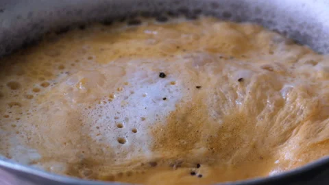 Close shot of indian chai tea boiling in a saucepan Stock Footage 147094493