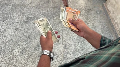 Close up shot of an Indian man counting currency cash outdoors 스톡 동영상 339216322