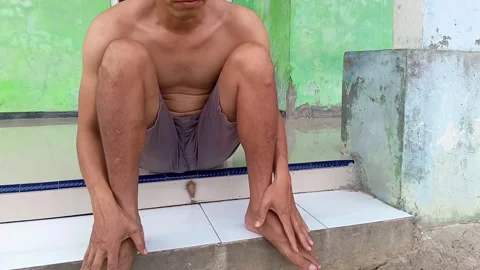 A close-up shot of an Indonesian man experiencing sharp pain. Stock Footage 321940113