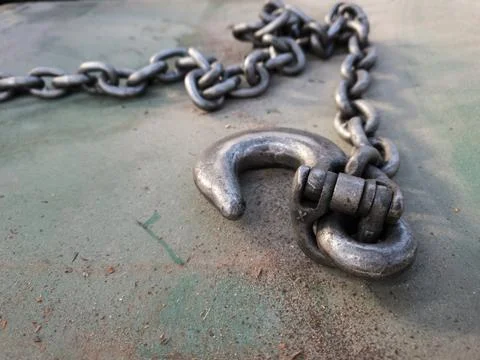 Close-up shot of an industrial metal hook and shackle on a chain. Stock Photos