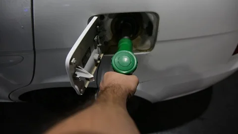 Close up shot of insertion of the nozzle and pumping gasoline into a white vehic Video stock 94041846