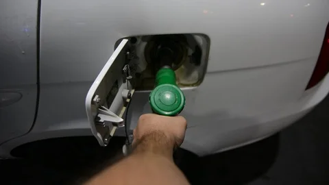 Close up shot of insertion of the nozzle and pumping gasoline into a white vehic Видео 94042068