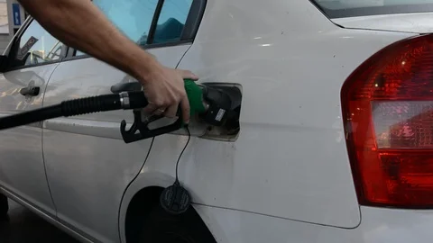 Close up shot of insertion of the nozzle and pumping gasoline into a white vehic 動画素材 94843743