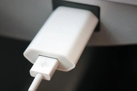 A close-up shot of an iPhone cable charging an iPhone 8 on a train Stock Photos