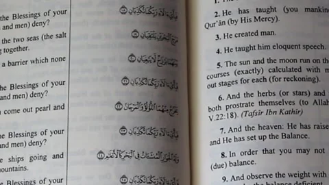 Close up shot for Islamic religion book. The opened Quran with verse of Rahman w Stock Footage