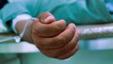 Close up shot of IV drip solution in a preteen patient's hand while lying down Vidéo 304905275