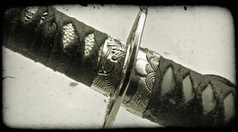 Close-up shot of a katana sword being pulled out of its sheath. Vintage stylized Stock Footage 52707461
