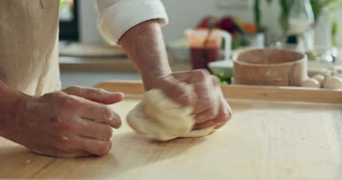 Close up shot kneading process. Man's hands preparing homemade domestic dough Видео 218633548