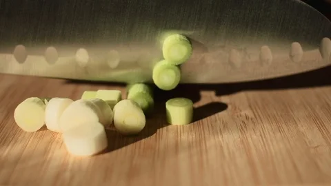 Close up shot of knife chopping spring onion on wooden cutting board. 4K resolut Stock Footage 118539747