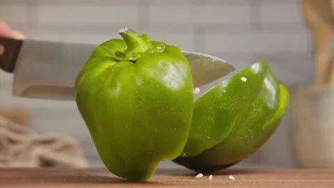 Close up shot of knife cutting green bell pepper in slow motion Stock Footage 152905409