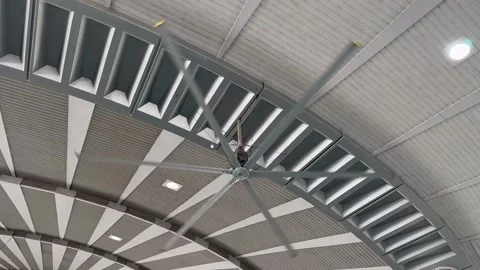 Close-up shot of a large rotating ceiling fan installed in a modern roof. Stock Footage 345260293