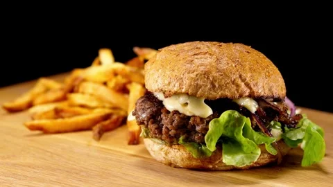 Close up shot of large tasty burger with beef steak, rotate on turntable burger Video stock 336579102