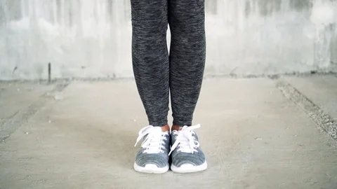 Close up shot of legs. Young athletic woman skipping with a jump rope. Stock Footage 112656911