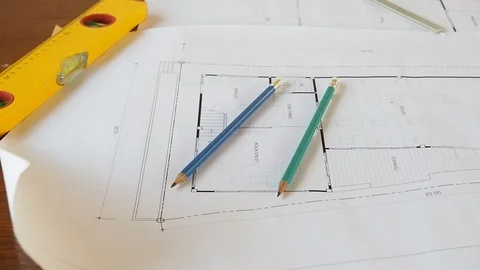 Close-up shot of level tool, pencils and ruler on architectural blueprints. Video stock 88741882